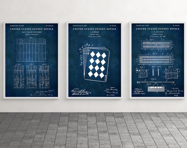 May include: Three framed patent prints on a blue background. The prints feature detailed diagrams and text, including "United States Patent Office" and patent dates. The central print showcases a playing card design.