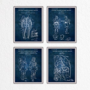 Puede incluir: Un conjunto de cuatro impresiones de patentes vintage azules y blancas con ilustraciones de diferentes trajes espaciales. Las impresiones están enmarcadas en un marco plateado y tienen un fondo azul desgastado.
