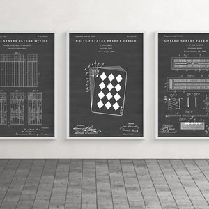 May include: Three framed patent prints on a dark gray background. The prints feature detailed white technical drawings and text, including "United States Patent Office." The middle print shows a playing card design.