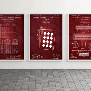 May include: Three framed patent prints with white diagrams on a deep red background. The prints feature designs for playing cards and a bridge score-sheet. The frames are white, and the prints are displayed on a gray floor.