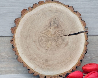 Round oak wood slice as live edge cake stand for rustic wedding table centerpiece. Can be personalized. 13-14 inch in diameter. Not treated