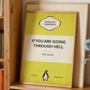 May include: A framed rectangular print featuring a yellow and white background with the text SPECIAL EDITION at the top, IF YOU ARE GOING THROUGH HELL KEEP GOING in the center, and the word COMPLETE on the left and UNABRIDGED on the right.