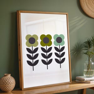 May include: A framed wall art print featuring three stylized flowers with dark gray centers and stems. The left flower is light green, the middle is olive green, and the right is mint green. Each flower has a symmetrical stem with six dark gray leaves.