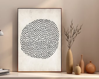 Puede incluir: Una impresión enmarcada con un diseño minimalista que presenta un círculo blanco y negro lleno de pequeños puntos sobre un fondo beige.