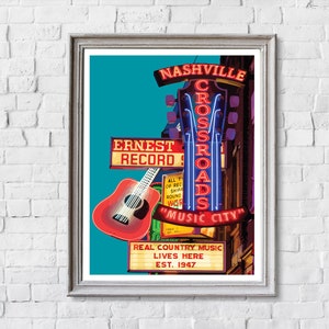 May include: A framed print featuring a vibrant illustration of a Nashville music venue. The artwork showcases neon signs that read "Nashville Crossroads" and "Music City," along with a red guitar. The text "Ernest Record" and "Real Country Music Lives Here" are also visible.