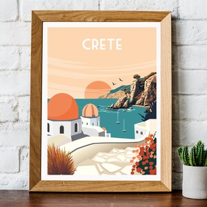 May include: A framed illustration of a sunset over a coastal town in Crete, Greece. The illustration features white buildings with orange domed roofs, a blue sea, and a rocky cliff in the background. The text "CRETE" is printed in white at the top of the illustration.