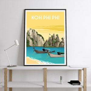 May include: A framed art print featuring a tropical beach scene with the text "KOH PHI PHI" at the top. The artwork depicts turquoise water, sandy beaches, and traditional longtail boats. Towering rock formations and a yellow sky complete the scene.