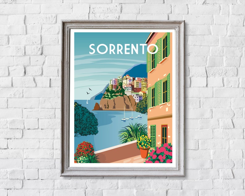 Pode incluir: Uma ilustra&ccedil;&atilde;o colorida de uma cidade com a palavra "SORRENTO" em letras brancas. A cena apresenta uma vista de uma cidade constru&iacute;da em um penhasco com vista para uma massa de &aacute;gua azul. A imagem &eacute; emoldurada com uma moldura marrom clara.