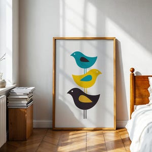 K&ouml;nnte beinhalten: Ein gerahmter vertikaler Wandkunstdruck mit drei stilisierten V&ouml;geln, die vertikal auf einer d&uuml;nnen Linie gestapelt sind. Der oberste Vogel ist blaugr&uuml;n mit einem schwarzen Fl&uuml;gel, der mittlere gelb mit einem blaugr&uuml;nen Fl&uuml;gel und der untere dunkelgrau mit einem gelben Fl&uuml;gel.