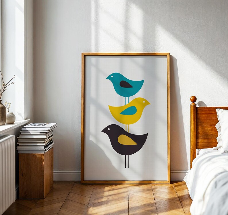 K&ouml;nnte beinhalten: Ein gerahmter vertikaler Wandkunstdruck mit drei stilisierten V&ouml;geln, die vertikal auf einer d&uuml;nnen Linie gestapelt sind. Der oberste Vogel ist blaugr&uuml;n mit einem schwarzen Fl&uuml;gel, der mittlere gelb mit einem blaugr&uuml;nen Fl&uuml;gel und der untere dunkelgrau mit einem gelben Fl&uuml;gel.