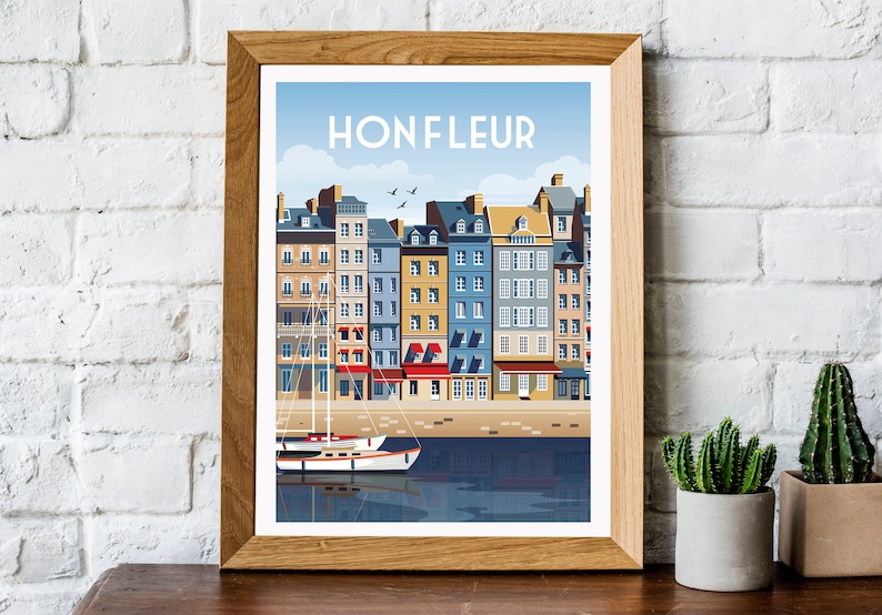 May include: A framed print of a colorful illustration of a waterfront cityscape with the text "Honfleur" at the top. The illustration features a row of colorful buildings with red roofs and a sailboat in the water.