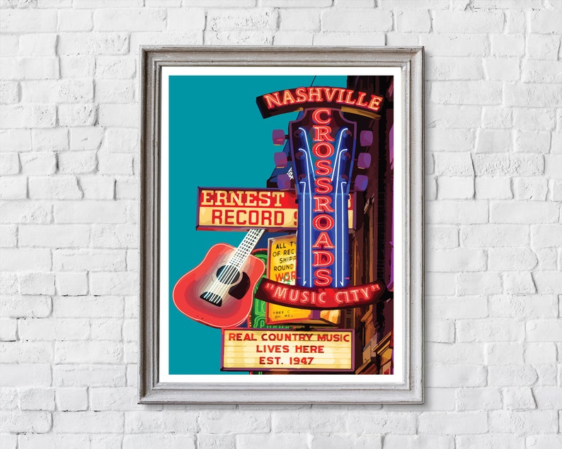May include: A framed print featuring a vibrant illustration of a Nashville music venue. The artwork showcases neon signs that read "Nashville Crossroads" and "Music City," along with a red guitar. The text "Ernest Record" and "Real Country Music Lives Here" are also visible.