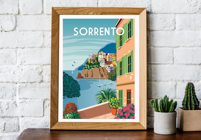 Pode incluir: Uma ilustra&ccedil;&atilde;o colorida da cidade de Sorrento, It&aacute;lia, com vista para o mar e um edif&iacute;cio com persianas verdes. A ilustra&ccedil;&atilde;o est&aacute; emoldurada em uma moldura de madeira.