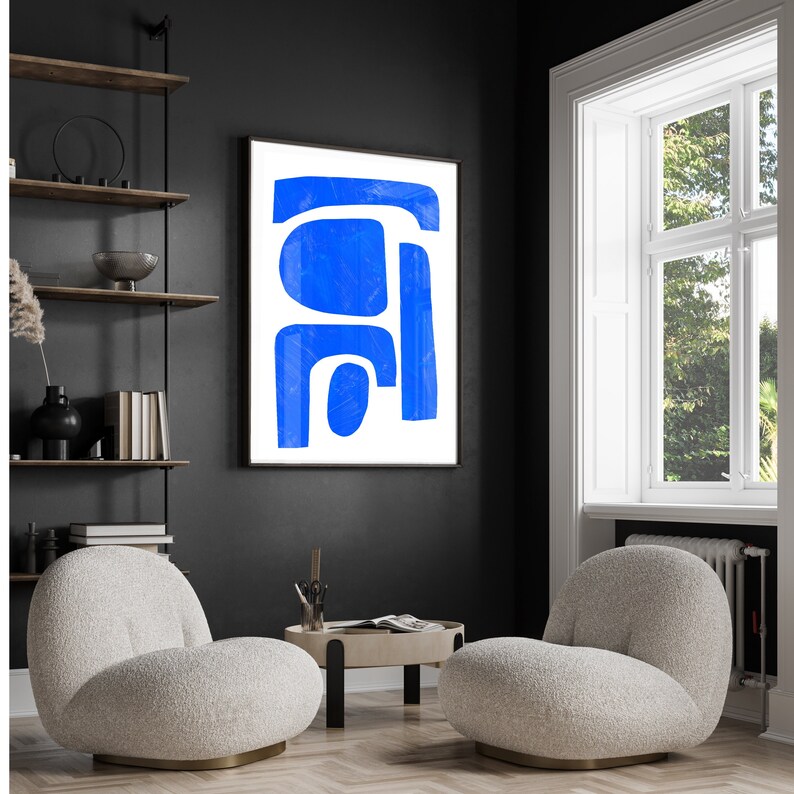 May include: A framed wall art piece featuring a white background with bold, abstract blue shapes. The artwork consists of a horizontal bar at the top, a large rounded square, and a vertical rectangular form with a smaller circular shape below.