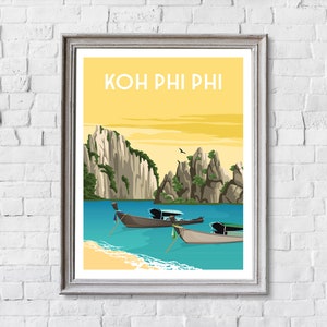 May include: Framed art print featuring a scenic illustration of Koh Phi Phi, Thailand. The artwork depicts a yellow sky, turquoise water, limestone cliffs, traditional boats, and the text "KOH PHI PHI" in a yellow font.