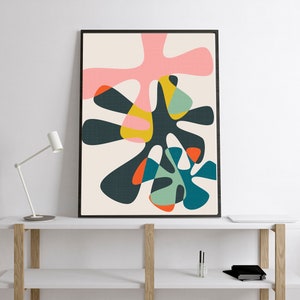 May include: A framed vertical wall art print featuring an abstract composition of overlapping organic shapes in shades of dark charcoal, soft pink, mustard yellow, teal, light green, and bright orange against a light cream background.