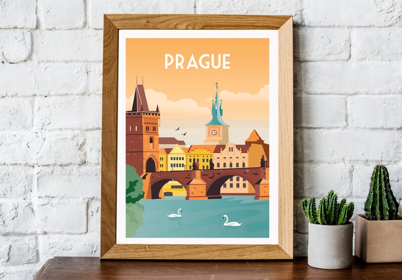 May include: A framed illustration of the Charles Bridge in Prague, Czech Republic. The illustration features a colorful cityscape with a bridge, buildings, and swans in the water. The text "PRAGUE" is at the top of the illustration.