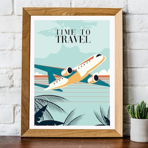 May include: A framed poster with a vintage travel theme. The poster features a white aeroplane flying over a blue and orange sunset with palm trees in the foreground. The text on the poster reads "Time to Travel".