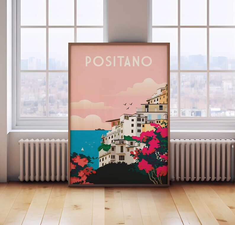 May include: A colorful poster with the text "POSITANO" in white letters on a pink background. The poster depicts a seaside town with colorful buildings, a blue sea, and pink flowers.