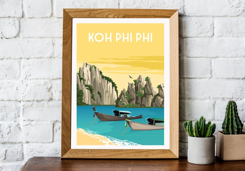 May include: A framed art print featuring a scenic illustration of Koh Phi Phi, Thailand. The artwork depicts a yellow sky, turquoise water, limestone cliffs, and traditional longtail boats. The text "KOH PHI PHI" is at the top.