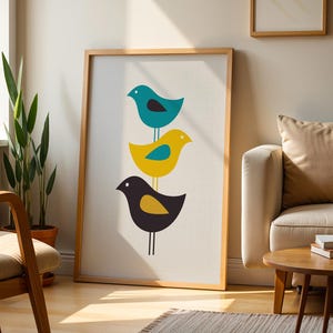 K&ouml;nnte beinhalten: Ein gerahmter vertikaler Wandkunstdruck mit drei gestapelten, stilisierten V&ouml;geln in einer Spalte. Der oberste Vogel ist blaugr&uuml;n mit schwarzem Fl&uuml;gel, der mittlere Vogel ist gelb mit blaugr&uuml;nem Fl&uuml;gel und der untere Vogel ist dunkelgrau mit gelbem Fl&uuml;gel.
