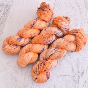Fil à chaussettes orange moucheté pour les doigts (75/25 mérinos/nylon Superwash) teint à la main avec des taches de violet, de bleu sarcelle et d'orange sur l'orange - 100 g