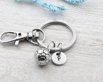 May include: Silver keychain with a silver soccer ball charm and a silver charm with the letter "P" on it.