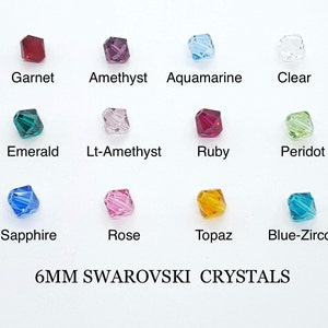 May include: Assortment of 6mm Swarovski crystals in various colors, including garnet, amethyst, aquamarine, clear, emerald, light amethyst, ruby, peridot, sapphire, rose, topaz, and blue zircon. 6MM SWAROVSKI CRYSTALS.