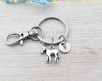 May include: Silver donkey keychain with a silver letter 'P' charm attached to a silver key ring.