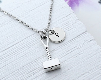 May include: Silver necklace with a small hammer charm and a round charm with the letter "P" on it.