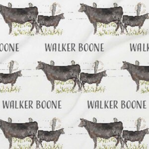 K&ouml;nnte beinhalten: Ein nahtloses Muster mit schwarzen K&uuml;hen und K&auml;lbern auf wei&szlig;em Hintergrund. Der Text "Walker Boone" wird im gesamten Muster wiederholt.