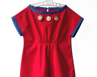 Red and Blue smock dress with Matryoshka (Russian nesting dolls) border and covered button trim.