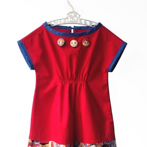 Red and Blue smock dress with Matryoshka (Russian nesting dolls) border and covered button trim.