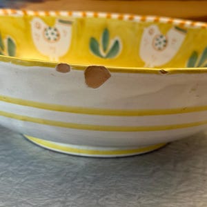 May include: A set of three ceramic nesting bowls in graduating sizes. The bowls feature a speckled, matte finish in shades of cream, light brown, and dark brown. The largest bowl measures approximately 8 inches in diameter.