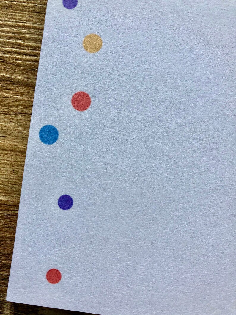 May include: A white sheet of paper with a row of colored dots down the left side. The dots are purple, yellow, red, blue, purple, and red.