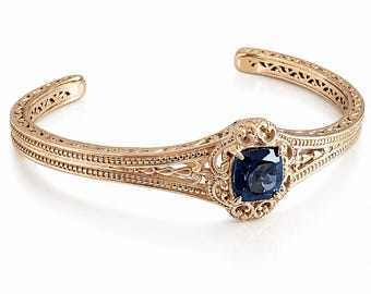 Bracciale rigido vintage in oro con gemma blu.