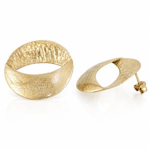 May include: A pair of gold-toned stud earrings featuring an open, oval-shaped design. Each earring has a textured, hammered surface on the upper half and a smooth, brushed finish on the lower half, with a standard post backing for secure attachment.