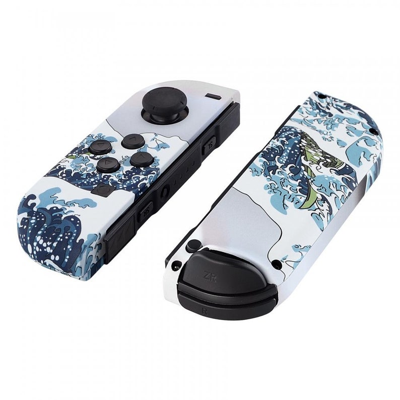 Peut inclure: Une paire de manettes Nintendo Switch Joy-Con blanches avec un motif de vagues bleu et blanc. Les manettes ont des boutons noirs et un joystick noir.