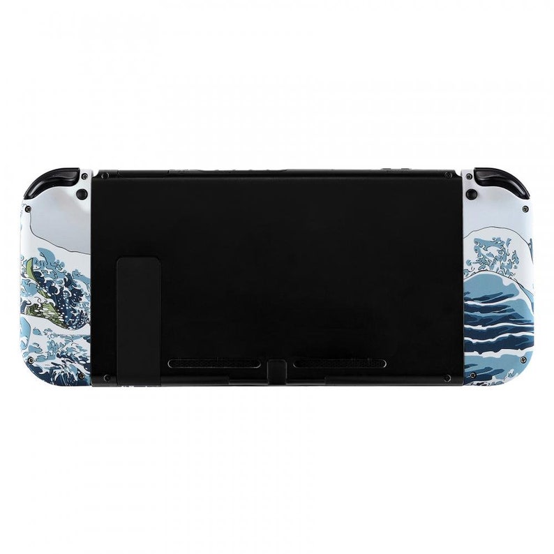 Peut inclure: Une console Nintendo Switch blanche avec un motif de vague bleu et blanc. La console a un &eacute;cran noir et une b&eacute;quille noire.