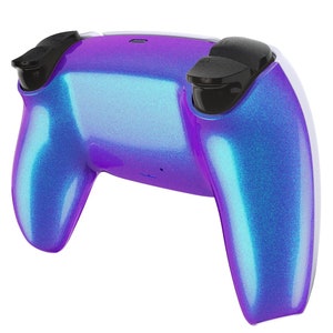 May include: A gaming controller with a pearlescent finish in shades of blue and purple. The controller has black thumbsticks and buttons, and a white accent on the sides. The design is sleek and modern.
