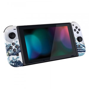 Peut inclure: Une console Nintendo Switch blanche avec un motif de vague bleu et blanc sur le dos. La console est en mode portable avec l'&eacute;cran allum&eacute;.