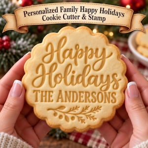 May include: A round, scalloped-edge cookie featuring the embossed text Happy Holidays and THE ANDERSONS, with a decorative sprig design at the bottom. The cookie is light tan in color with a smooth, baked texture and clear, legible lettering.