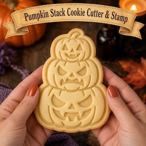 Puede incluir: Un cortador y sello de galletas beige con un diseño apilado de tres calabazas con caras de linterna talladas. La calabaza superior tiene una expresión sonriente, mientras que las del medio y la inferior presentan expresiones más agresivas con dientes afilados. El texto Pumpkin Stack Cookie Cutter & Stamp se muestra en una pancarta sobre el objeto.