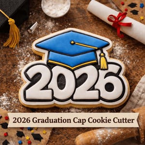 Può includere: Un tagliabiscotti a tema laurea a forma di cappello di laurea con l'anno 2026. Il biscotto è decorato con glassa blu, gialla e bianca. Il testo "2026 Graduation Cap Cookie Cutter" è visibile.