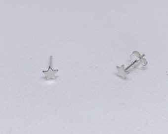 May include: A pair of silver star stud earrings. The earrings are small and delicate, with a simple star design.