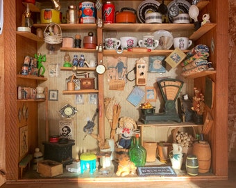 May include: A miniature wooden shop with shelves stocked with various items, including a red can labeled "Silver", a small basket, a broom, a scale, and a doll. The shop has a sign that reads "Welcome".