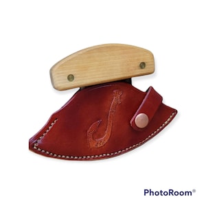 Op de afbeelding: Een bruine leren schede met een haakontwerp en een houten handvat. De schede heeft een messingknop en is ontworpen om een mes te bevatten.