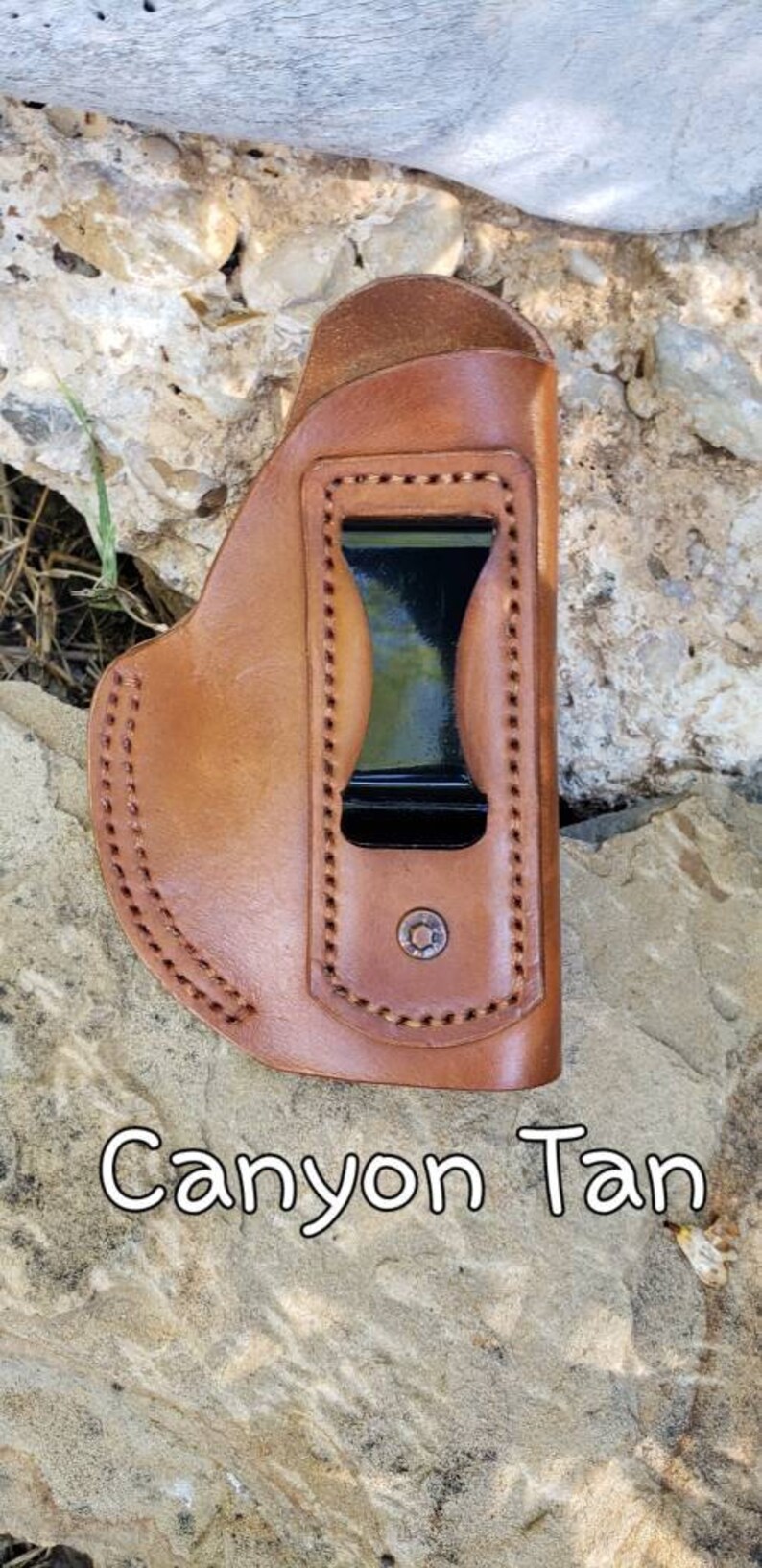 Puede incluir: Una funda de cuero marr&oacute;n con un clip negro y costuras. La funda est&aacute; etiquetada como "Canyon Tan".