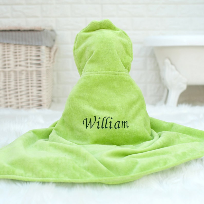 Puede incluir: Una toalla con capucha de color verde lima con el nombre "William" bordado en la parte delantera.