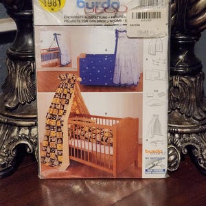 May include: A Burda Deco sewing pattern for a crib canopy and bedding set. The pattern is for a crib canopy with a star pattern, a crib skirt with a star pattern, and a crib blanket with a star pattern. The pattern is from 1981 and is for children's rooms.